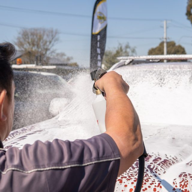 Snow foam being sprayed over a dual cab ute at a detailing day