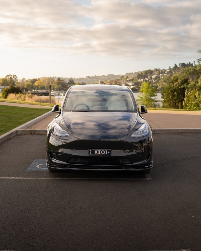 Black 2024 Tesla Model Y, front view beside the Tamar River in Launceston